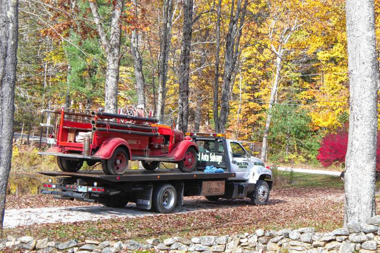 A 1936 Ford fire truck is moved from a barn in Wilton to Blanchard’s Auto Salvage, where volunteers will work to restore it to make it ready for the road for parades and displays.